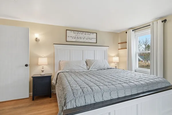 a bedroom with a bed and wooden floor