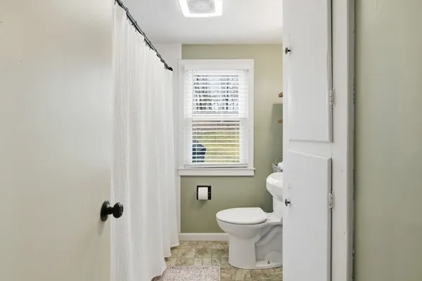 a bathroom with a toilet sink and a window