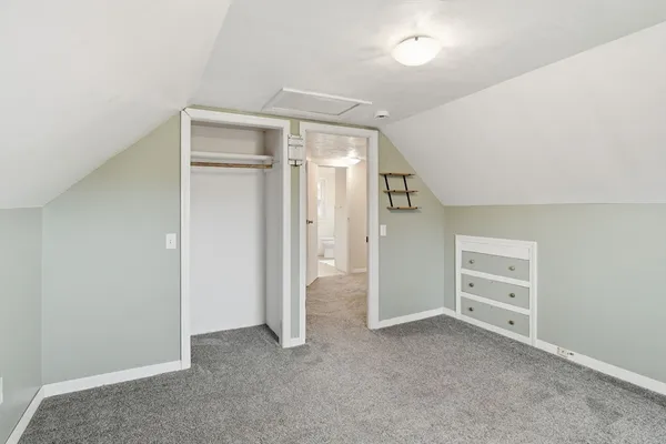 an empty room with closet and windows