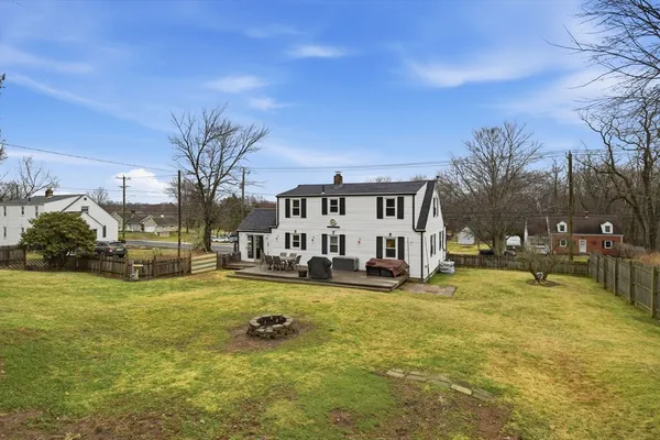 a view of a swimming pool with lawn chairs and a large tree