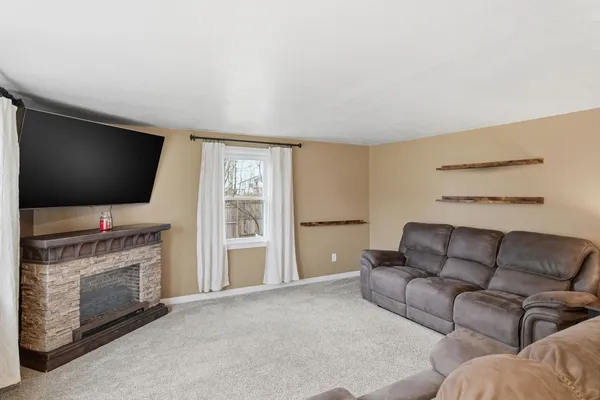 a living room with furniture a flat screen tv and a fireplace