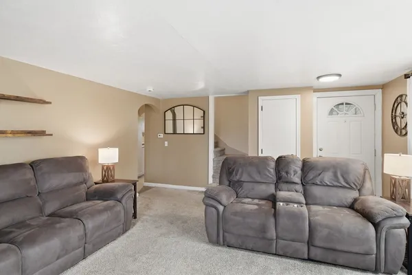 a living room with furniture white walls and a window