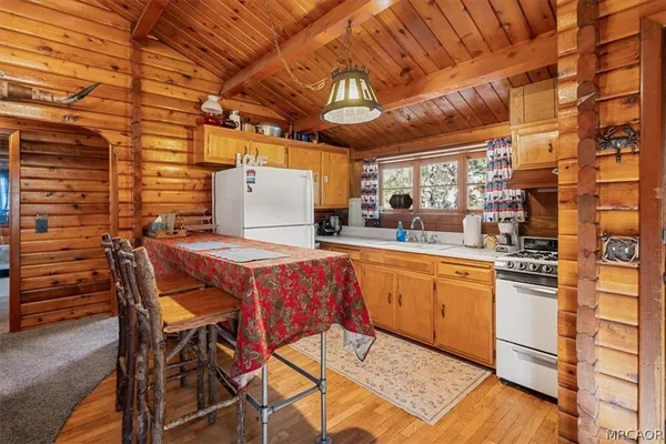 a kitchen with stainless steel appliances granite countertop a sink a stove a chimney and a refrigerator