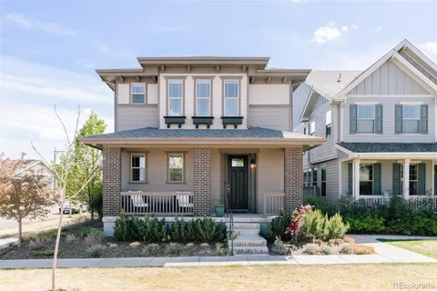 a front view of a house with a yard and potted plants