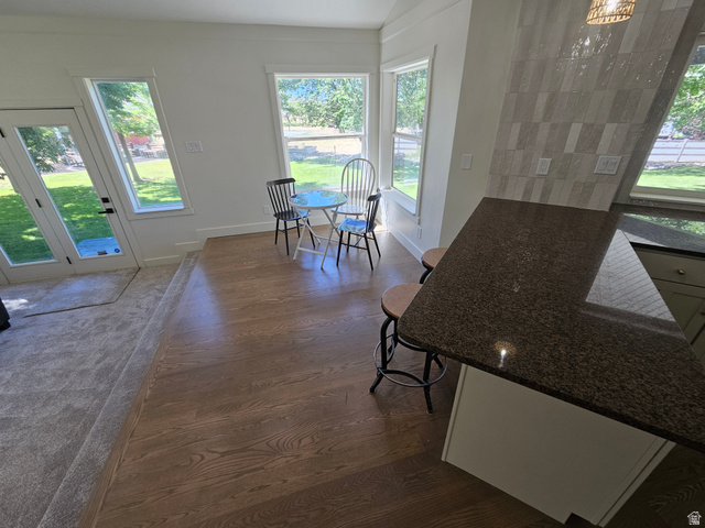 812 East Bates Cyn Road Tooele, UT 84074 - Photo 28 of 144 Kitchen island with a dark granite countertop, light-toned cabinetry, and a patterned tile backsplash