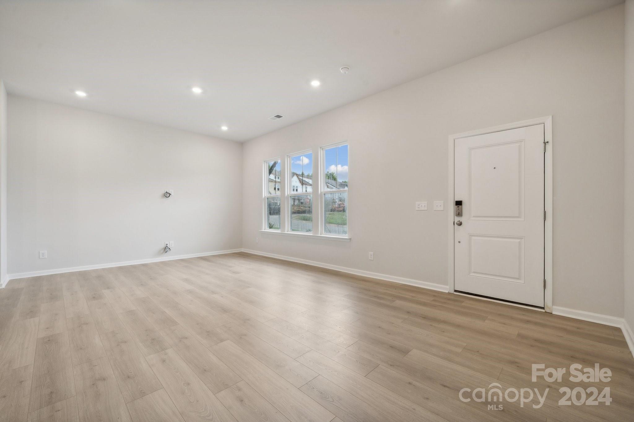 8606 Miles Gap Road Indian Land, SC 29707 - Photo 4 of 26 an empty room with wooden floor and windows
