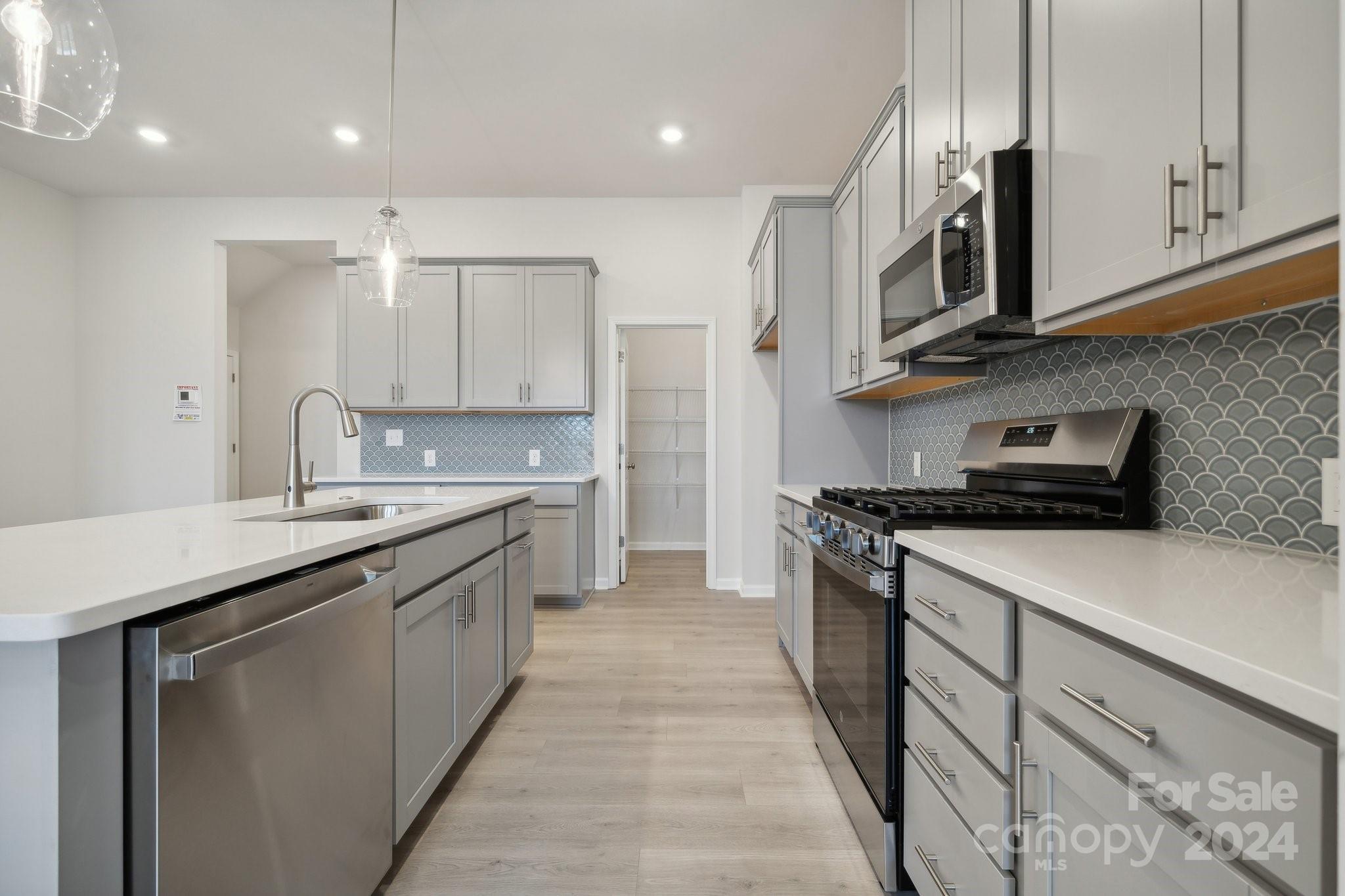 8606 Miles Gap Road Indian Land, SC 29707 - Photo 7 of 26 a kitchen with stainless steel appliances granite countertop a sink a stove and a refrigerator