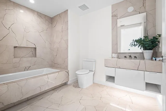 a balcony with couple of chairs and a potted plant