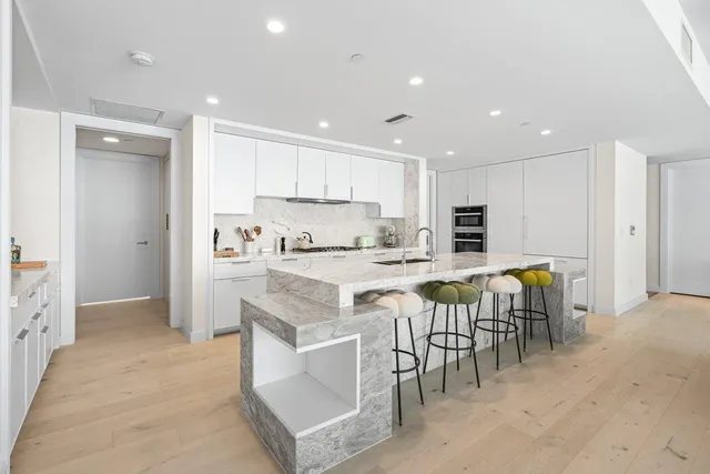 a large white kitchen with a stove and a sink