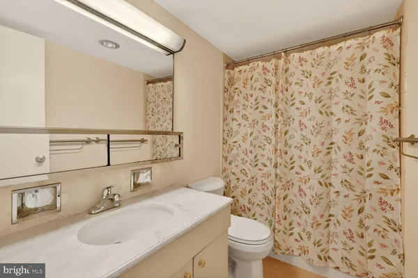 a bathroom with a sink toilet and mirror