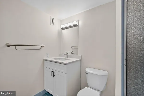 a bathroom with a toilet a sink and mirror