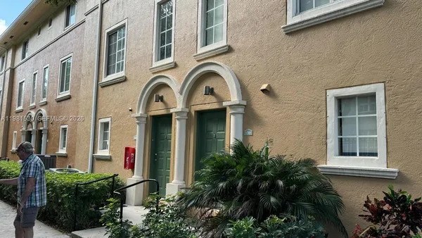 a front view of a multi story residential apartment building with a yard