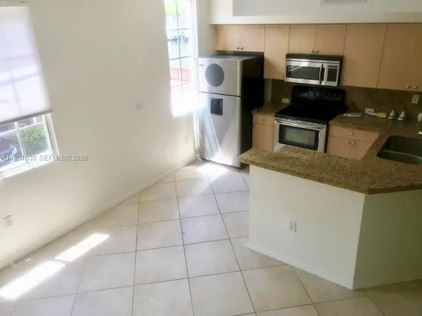 a kitchen with a sink a microwave a refrigerator and counter space