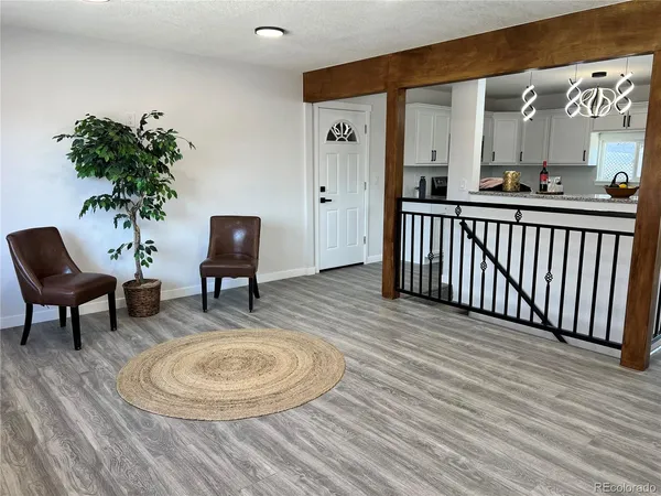 a view of a room with wooden floor and furniture