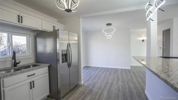 a kitchen with white cabinets and black appliances