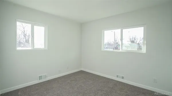an empty room with windows and cabinet
