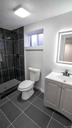 a bathroom with a granite countertop sink a toilet and a mirror