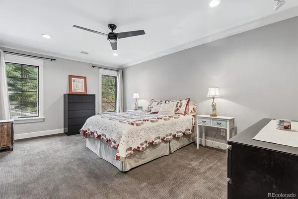 a spacious bedroom with a bed and a ceiling fan