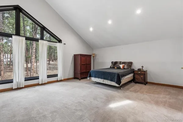 a spacious bedroom with a bed and a ceiling fan