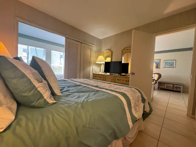 a bedroom with a bed and large windows