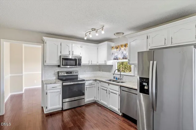 a kitchen with stainless steel appliances a refrigerator sink and microwave