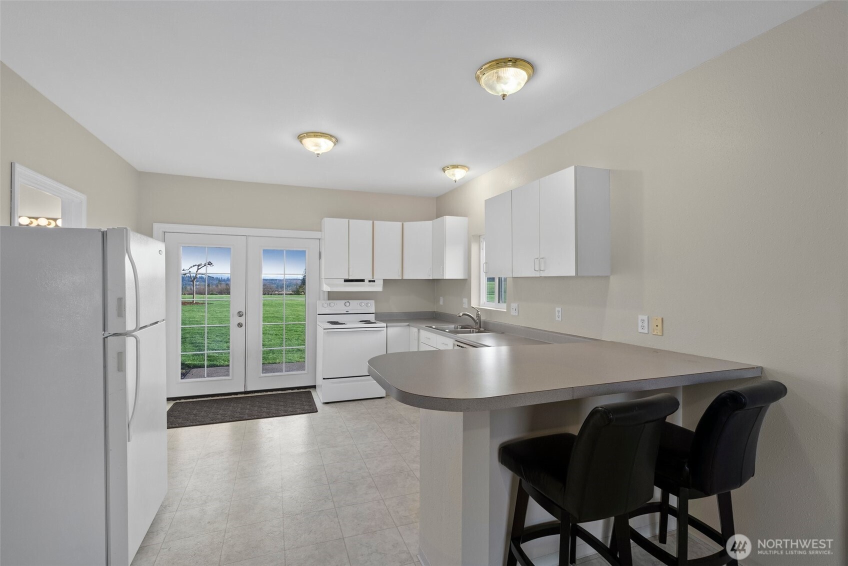 198 Short Road Onalaska, WA 98570 - Photo 24 of 40 a kitchen with a table chairs refrigerator and cabinets