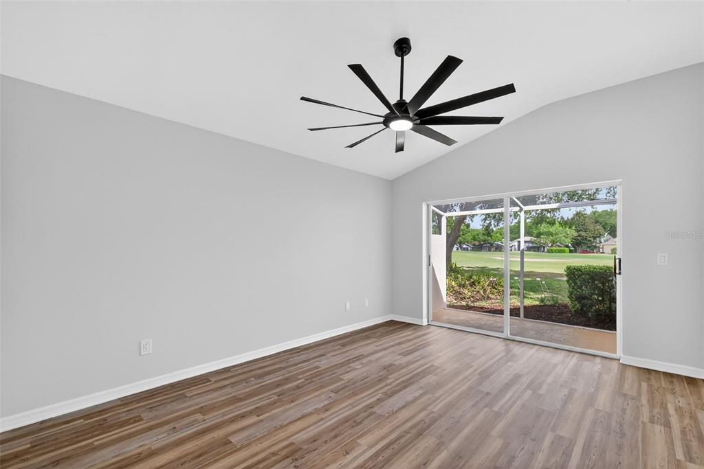 6027 Spring Creek Court Mount Dora, FL 32757 - Photo 17 of 42 an empty room with wooden floor and windows