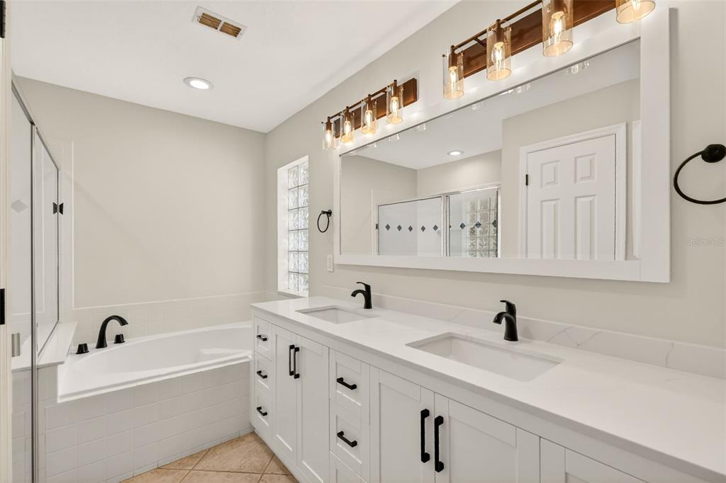 6027 Spring Creek Court Mount Dora, FL 32757 - Photo 20 of 42 a bathroom with a double vanity sink double mirror and bathtub