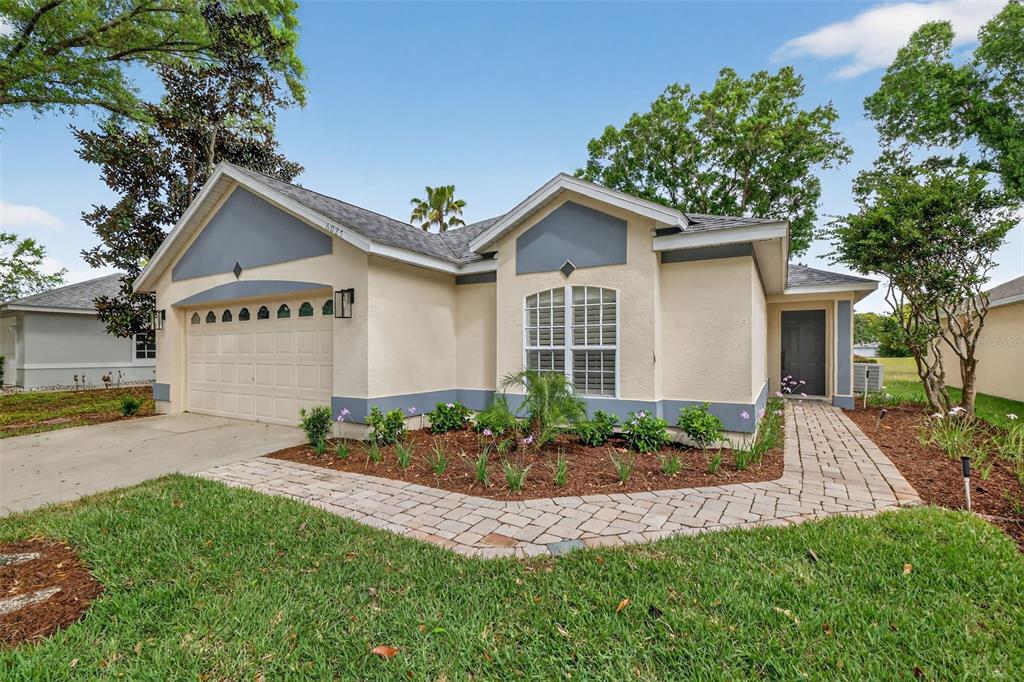 6027 Spring Creek Court Mount Dora, FL 32757 - Photo 2 of 42 a front view of a house with a yard and garage