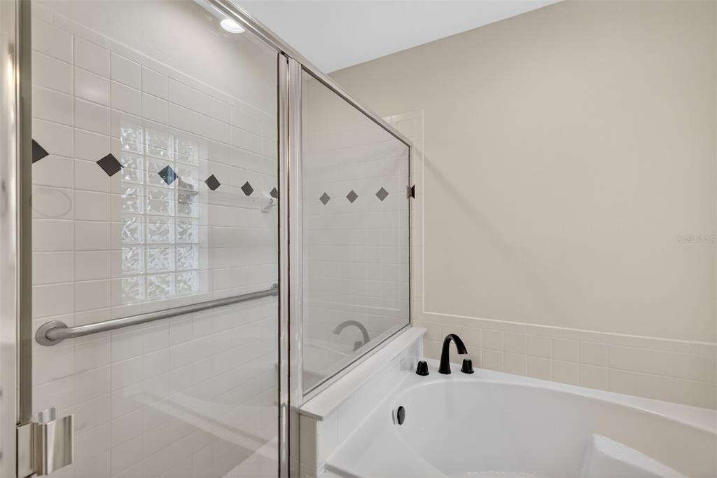 6027 Spring Creek Court Mount Dora, FL 32757 - Photo 21 of 42 a bathroom with a tub and a shower