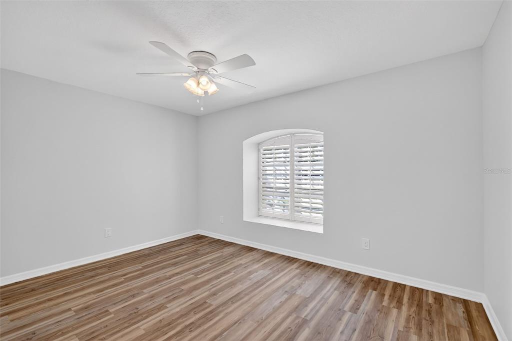 6027 Spring Creek Court Mount Dora, FL 32757 - Photo 22 of 42 wooden floor in an empty room with a window