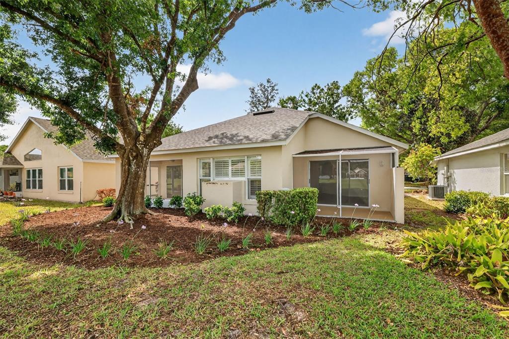 6027 Spring Creek Court Mount Dora, FL 32757 - Photo 35 of 42 a view of a yard in front of a house with large windows