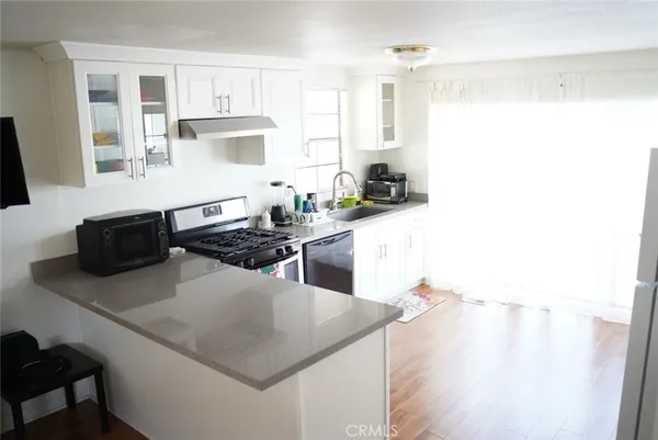 a kitchen with stainless steel appliances a stove a sink a microwave and a refrigerator