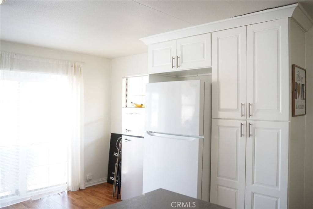 1010 Terrace Road, Unit 38 San Bernardino, CA 92410 - Photo 11 of 16 a view of kitchen with white cabinets and wooden floor