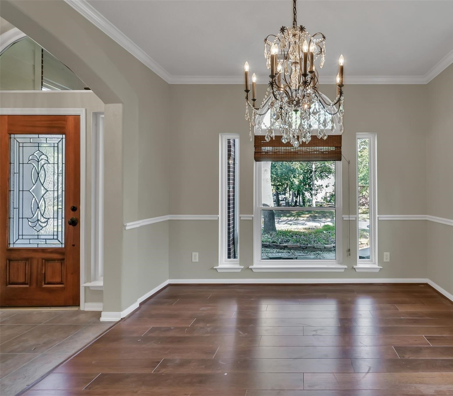 30 South Rambling Ridge Place Conroe, TX 77385 - Photo 4 of 15 an empty room with wooden floor chandelier and windows