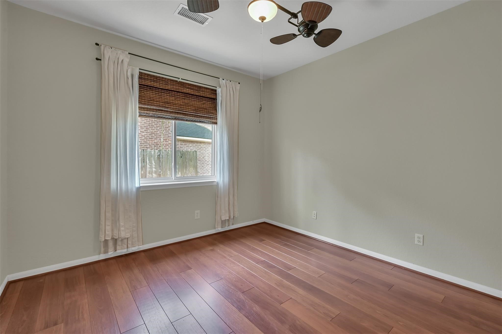 30 South Rambling Ridge Place Conroe, TX 77385 - Photo 6 of 15 a view of an empty room with wooden floor and a window