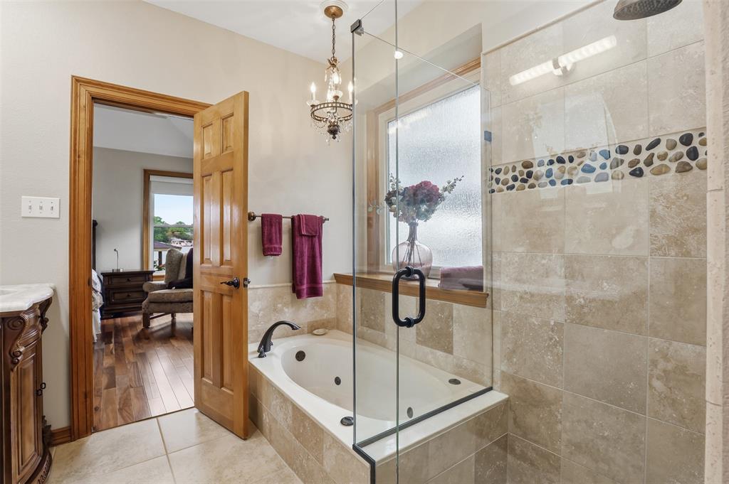 2406 River Road Granbury, TX 76048 - Photo 19 of 40 a bathroom with a tub a sink and a mirror