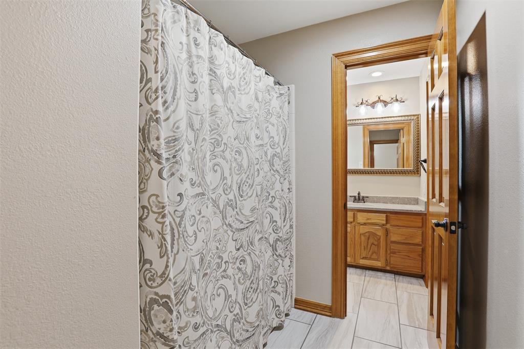 2406 River Road Granbury, TX 76048 - Photo 23 of 40 a bathroom with a shower and a sink