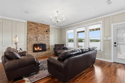 a living room with furniture a fireplace and a chandelier