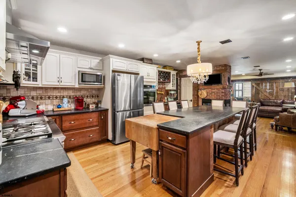 a kitchen with stainless steel appliances granite countertop a stove refrigerator and cabinets