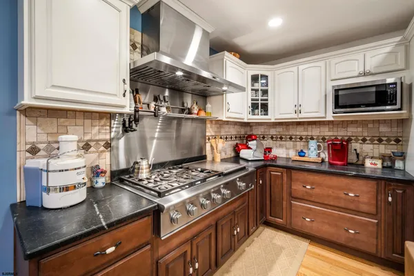 a kitchen with stainless steel appliances granite countertop a sink stove and cabinets