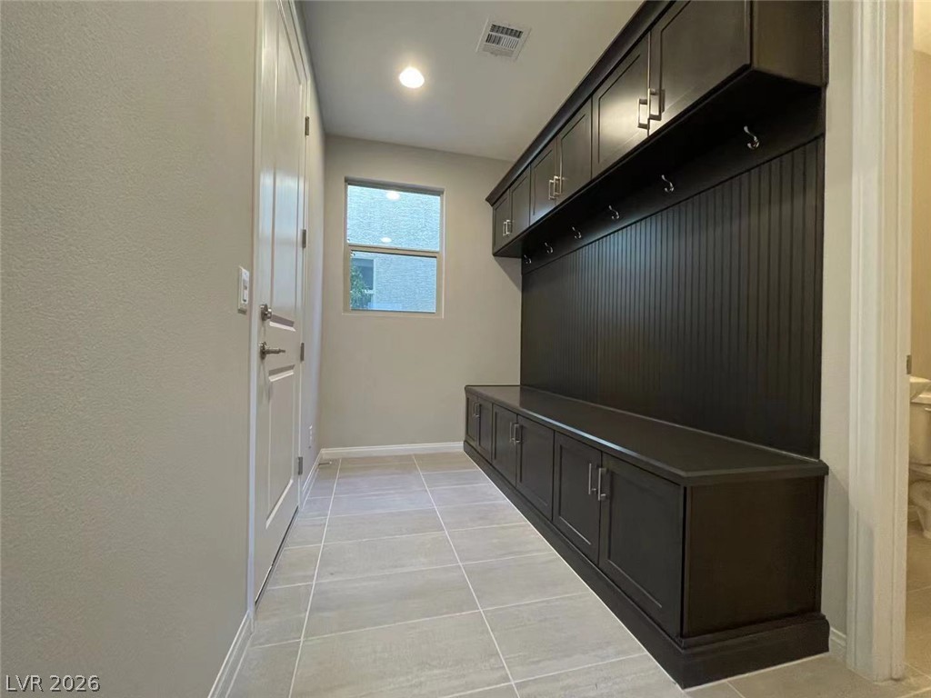 11 Rancho Maria Street Las Vegas, NV 89148 - Photo 10 of 27 A functional mudroom features custom built-in cabinetry, durable tile flooring, and integrated bench seating.