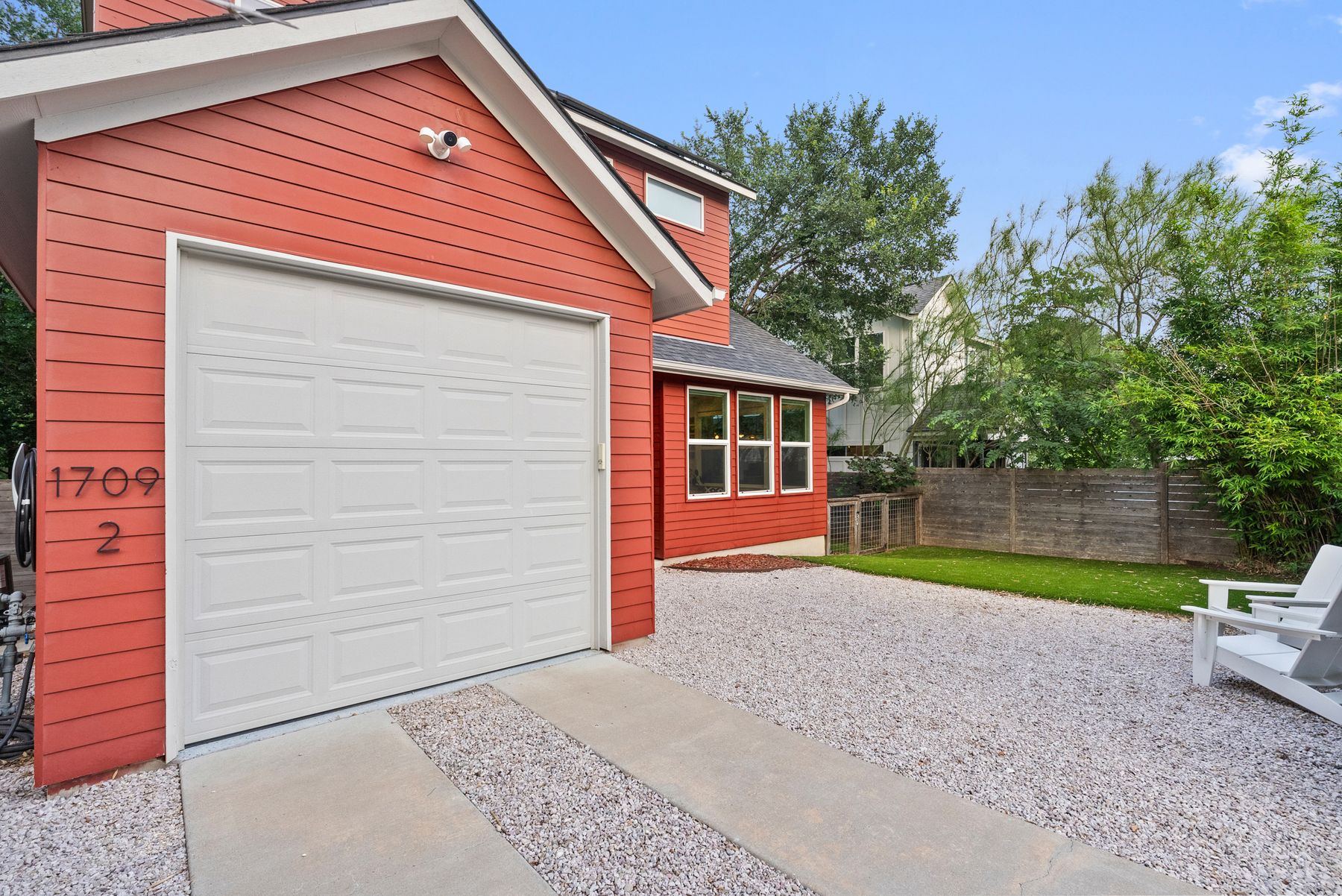 1709 Perez Street, Unit 2 Austin, TX 78721 - Photo 3 of 33 A well-maintained gravel driveway leads to a single-car garage with a cheerful red siding.