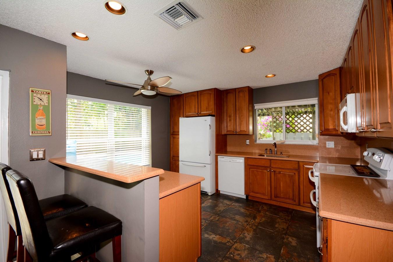 6896 Long Key Street Lake Worth, FL 33467 - Photo 8 of 18 a kitchen with kitchen island a stove a sink a refrigerator dining table and chairs