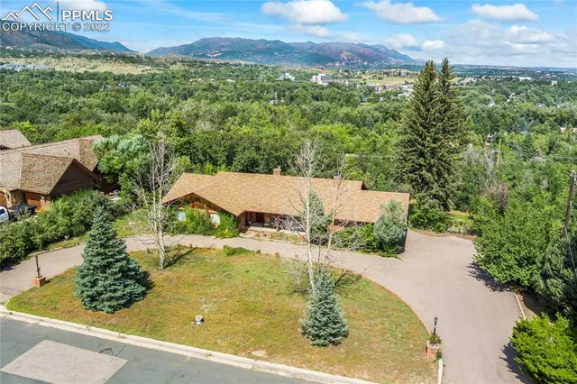 an aerial view of residential houses with outdoor space and trees