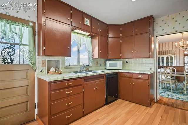 a kitchen with a sink window and cabinets