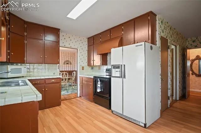 a kitchen with stainless steel appliances granite countertop a refrigerator and a stove top oven