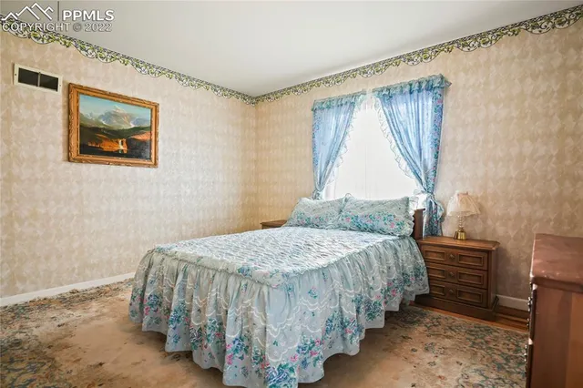 a bedroom with a bed and a painting on the wall