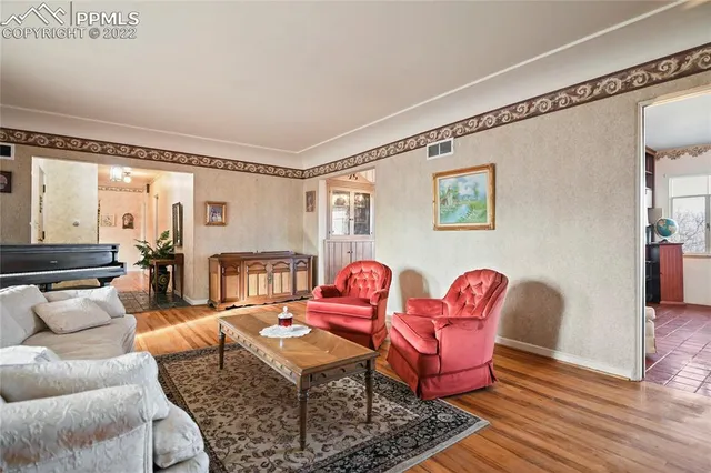 a living room with furniture a rug and a table