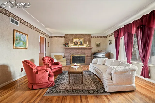 a living room with furniture fireplace and a large window